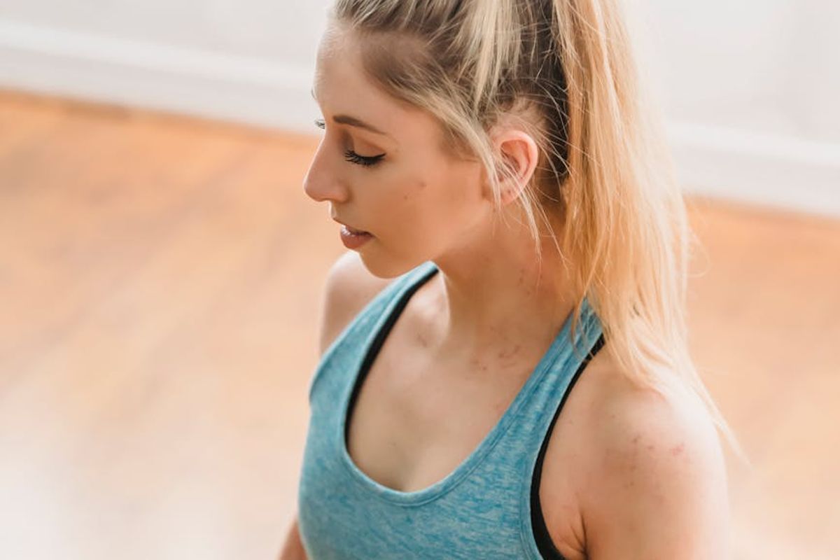 A serene woman practicing a gentle yoga stretch in a calm environment.